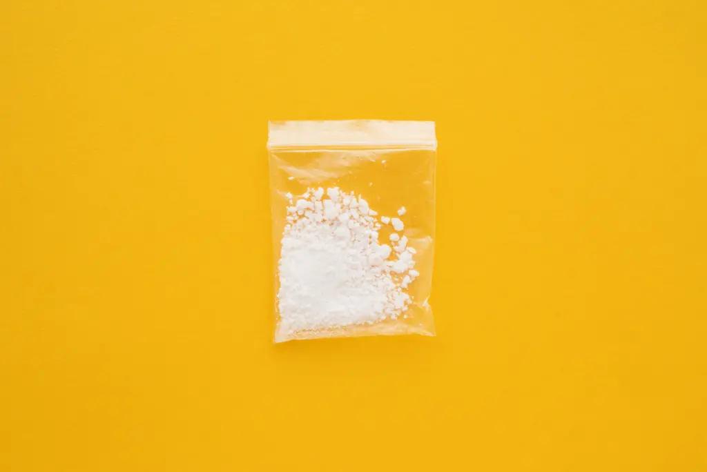 Cocaine drug in resealable bag on bright yellow background