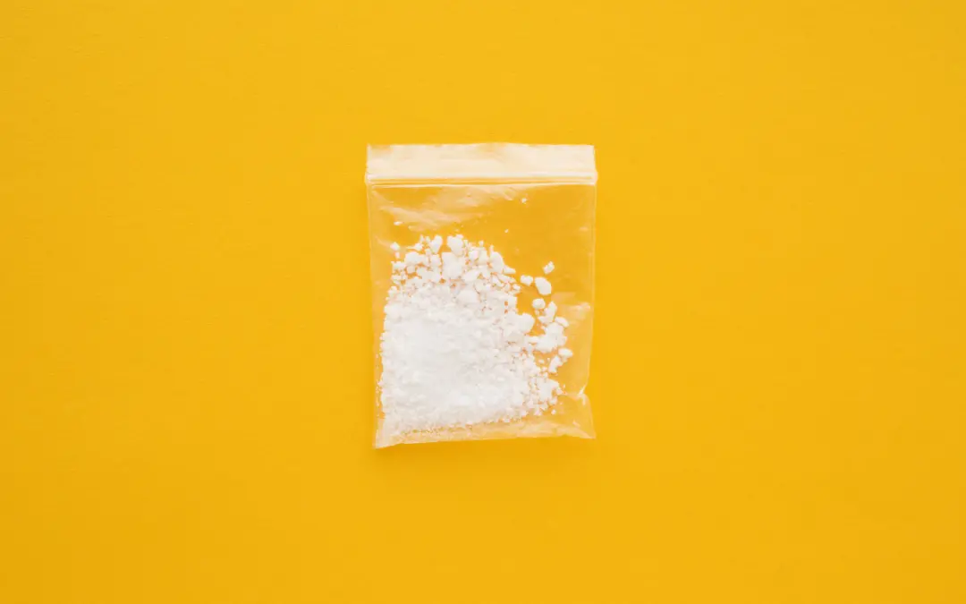 Cocaine drug in resealable bag on bright yellow background
