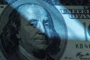 US Dllar bill in the shadow as symbol of corruption, wages in an envelope, fraud and financial manipulation